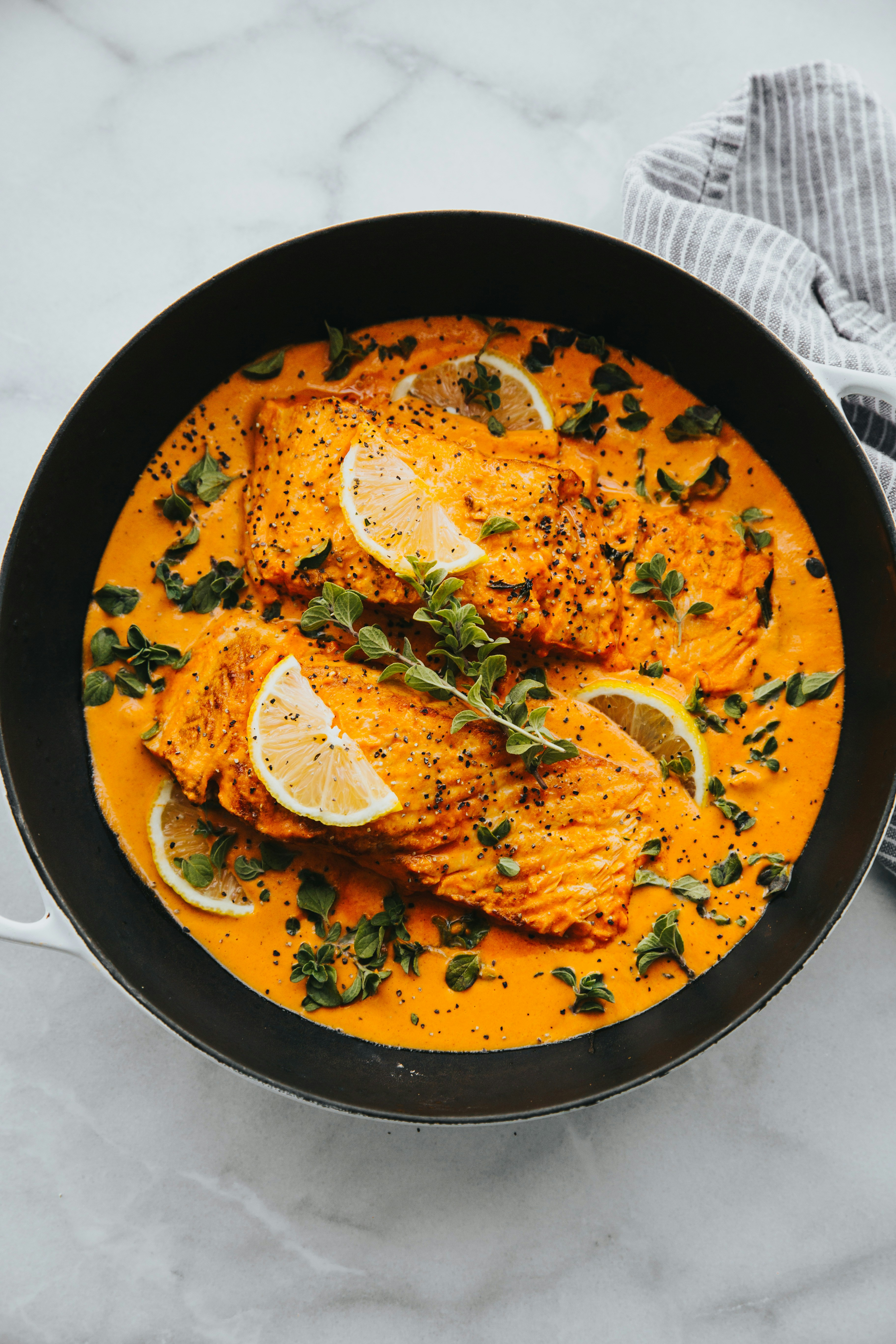 Creamy salmon recipe in a skillet with lemon and herbs