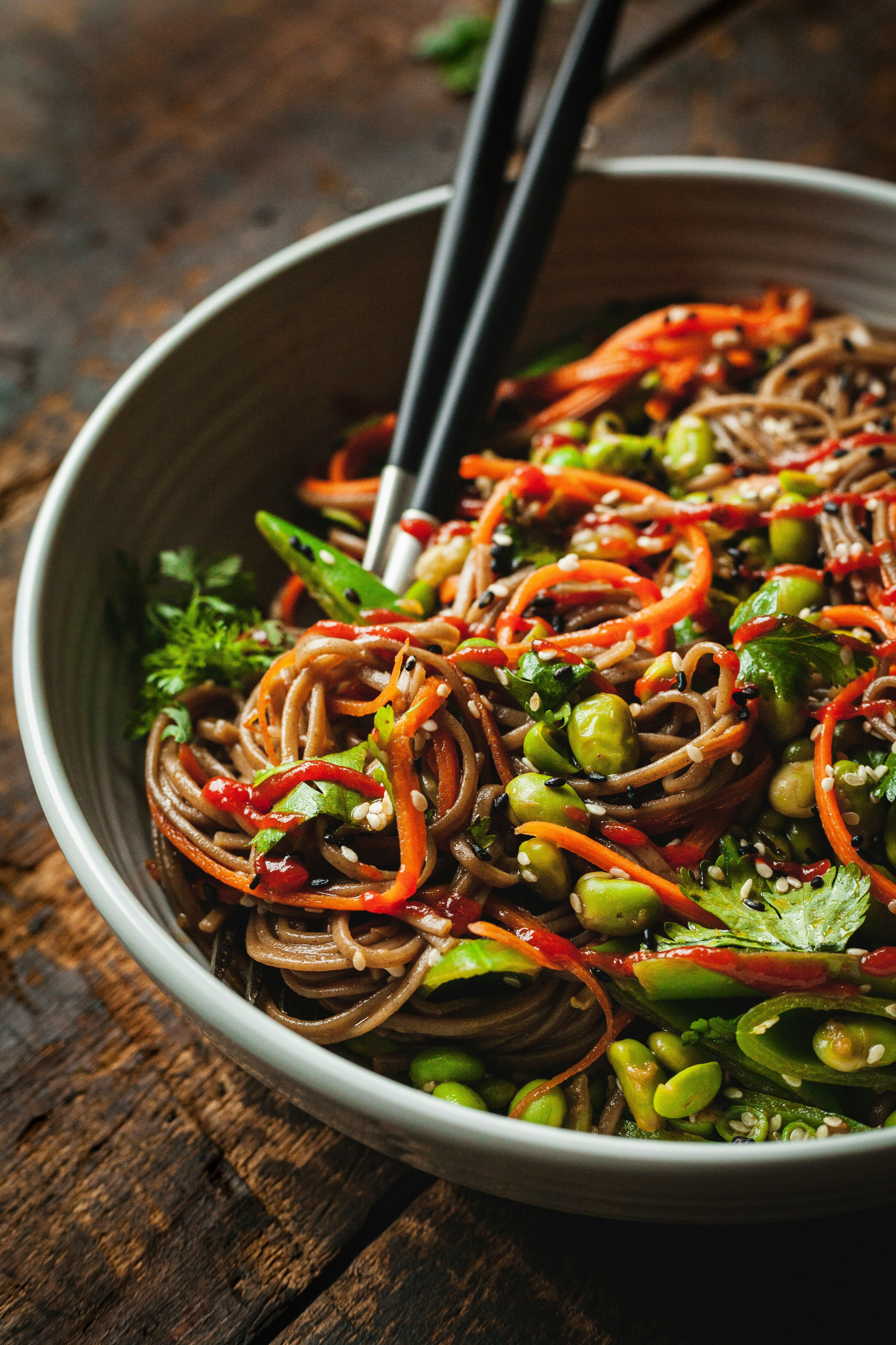 Soba noodle bowl with vegetables and chopsticks