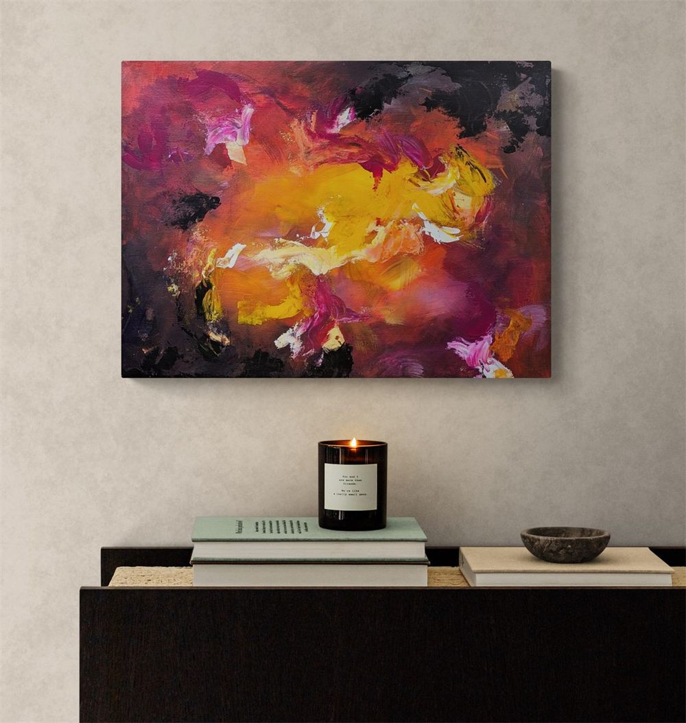 Radiance by Jade Boswell: a fiery, deeply feminine abstract painting in yellow, orange, magenta and deep purple, an eruption of warmth and confidence, hung above a dark sideboard